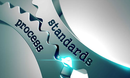 Two gears set against each other. One one it says "process". The other says "standards".